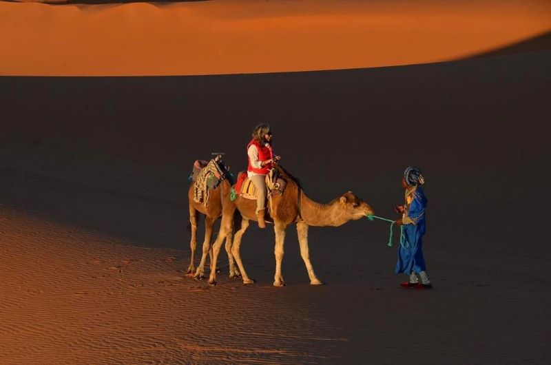 Camello en el desierto Imagen de una chica en el desierto paseando encima de un camello